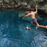 Wisatawan lokal menikmati kesegaran danau Moko dengan melompat dari tepiannya.