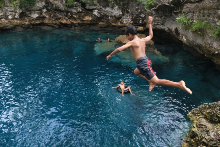 Wisatawan lokal menikmati kesegaran danau Moko dengan melompat dari tepiannya.